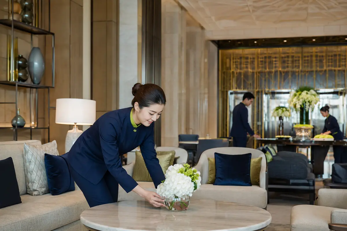 Professional hospitality staff preparing a guest space